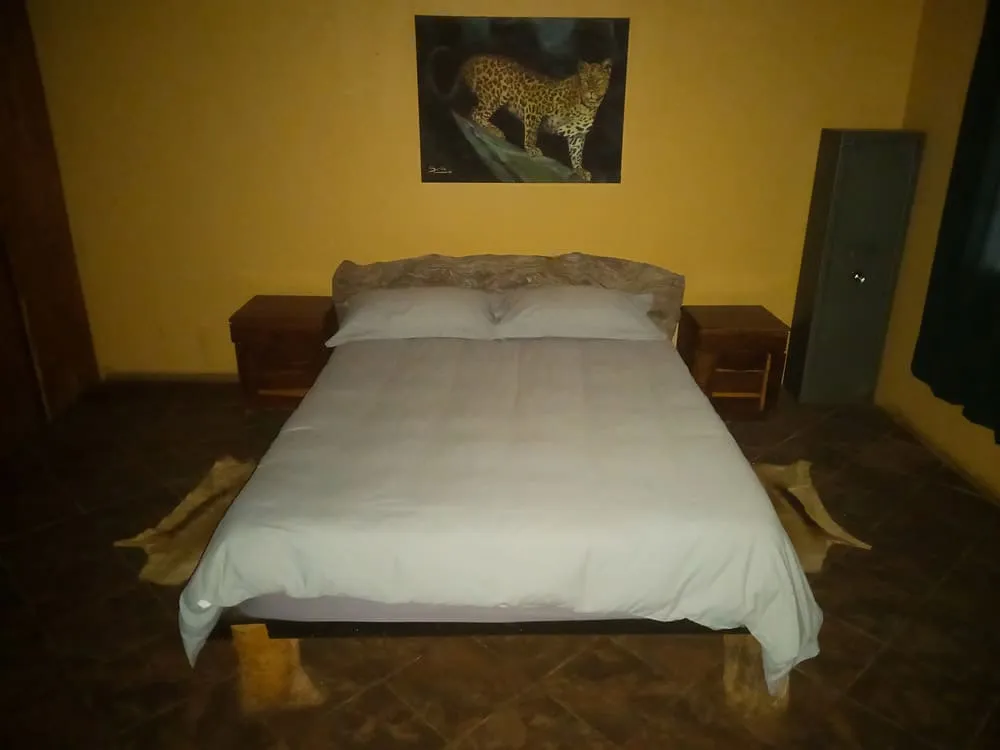 Dormitorio principal del lodge, acogedor y funcional, diseñado para el descanso tras un día de caza o safari en plena bushveld africana.